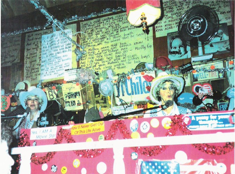 The wall of the 737 Main Pub, covered in hand-lettered signs and hats